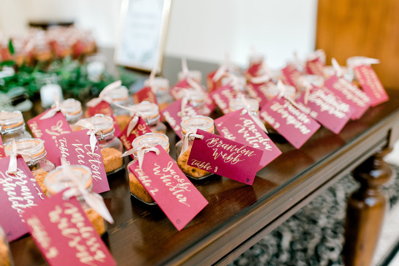 wedding favor ideas: miniature bottles of spices are lined up on a table. each one has a tag with the guest