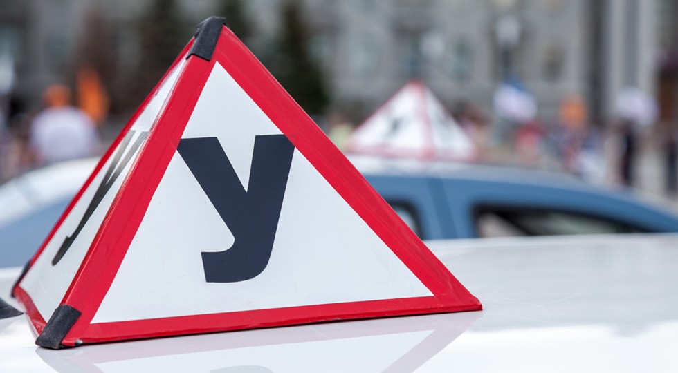 Sign of a Russian Driving School on top of the vehicle