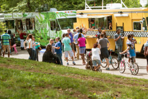 ATLANTA, GA - APRIL 2016: A large crowd of people buy meals from food trucks lined up in Grant Park at the Food-o-rama festival in Atlanta GA on April 16 2016 .
