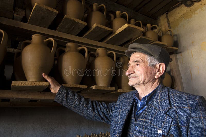 Master male potter and his handmade clay vases. Bilecik, Turkey; March 21, 2010; Master male potter and his handmade clay vases royalty free stock photo