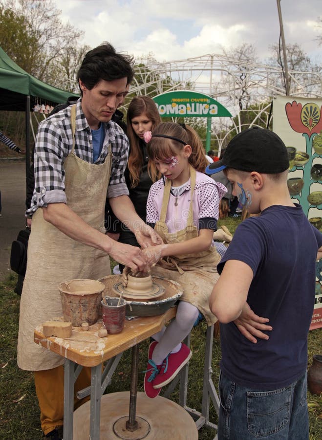 Children study the modelling on the art master-class at outdoor. KIEV, UKRAINE - MAY 01, 2015: Unknown children study the modelling on the art master-class at royalty free stock images