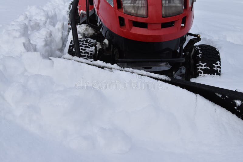 Clearing snow plow garden tractor. Snow. Winter season stock photos
