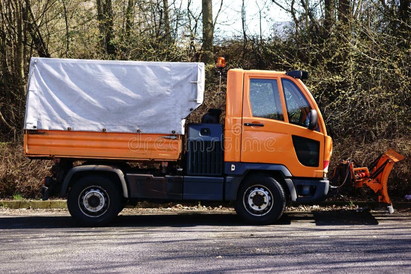 Clearing vehicle with plow. The side view of a small clearing vehicle with plow and loading area royalty free stock image