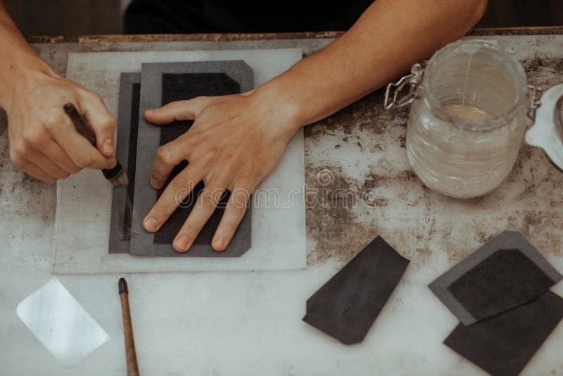 Close up of master making leather wallet with brush and glue. Handmade master at work in local workshop. Handmade. Concept. Leather craft. Top view stock images