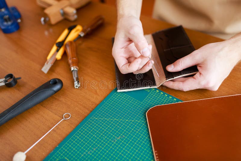 Handcraft. Human hands stitching leather wallet royalty free stock photos