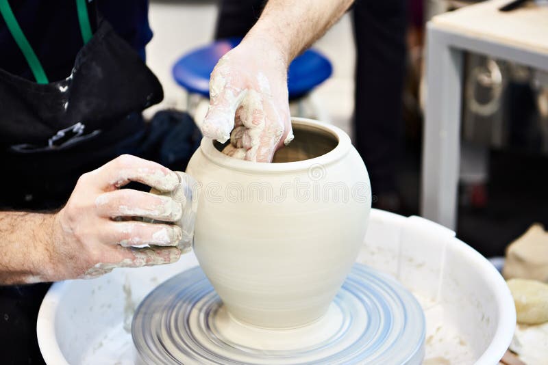 Hands of master in pottery workshop. Hands of a master in a pottery workshop royalty free stock photo