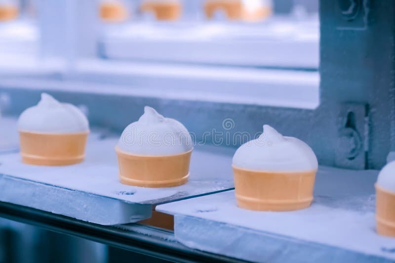 Ice cream automatic production line - conveyor belt with icecream cones stock photo