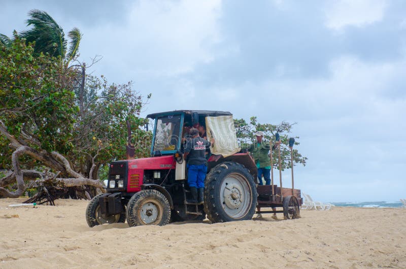 Tractor on resort beach clearing weed. Jibacoa Cuba - 25 January 2018: Tractor on resort beach clearing weed stock images