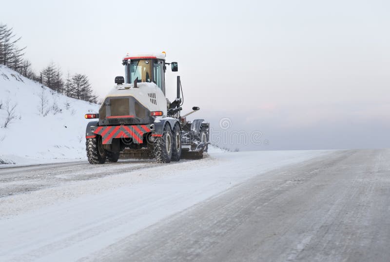 Machine cleans snow from the road royalty free stock image