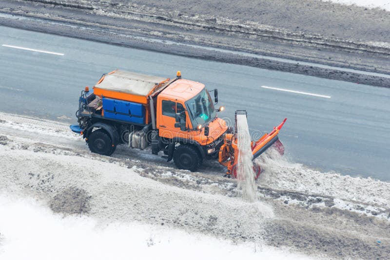 Machinery snowplough cleaning highway by removing cleans snow swinging on the side of the road stock photography