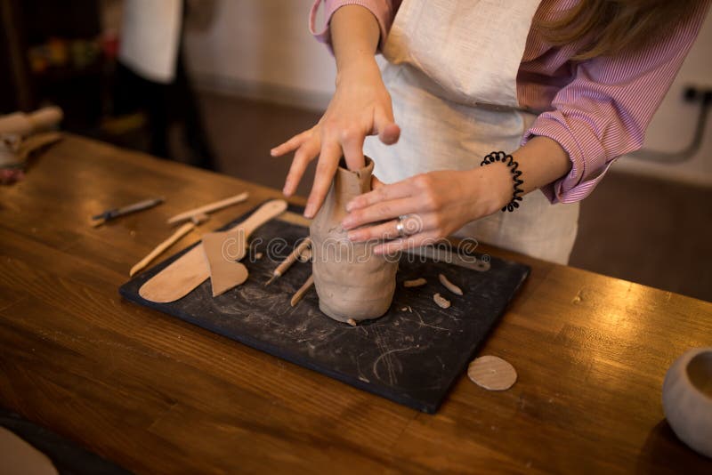 A master class in modeling a clay jug. The girl is engaged in modeling. Close-up royalty free stock photography