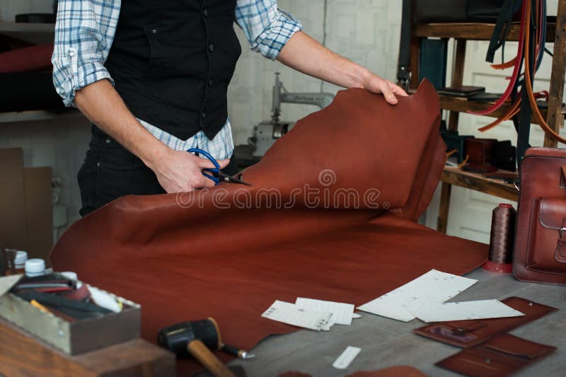 Master sewing leather goods, concept of handmade craft production. Of leather goods stock photos