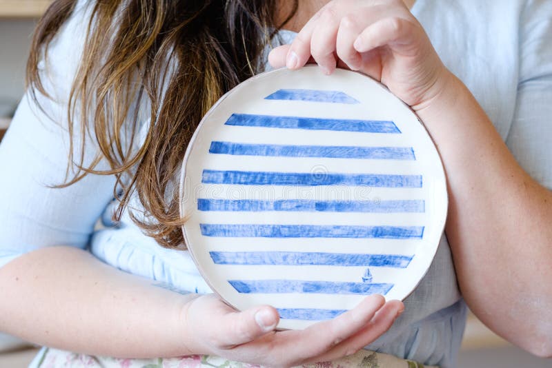 Pottery handcraft hobby handmade clay plate. Pottery handcraft hobby. woman showing a handmade clay plate royalty free stock photo