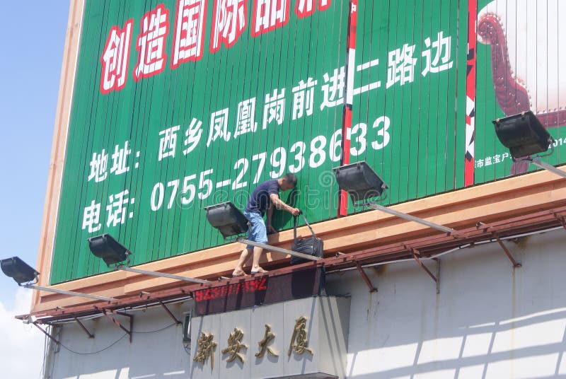 Shenzhen, China: installation of advertising signs. Shenzhen Baoan Xixiang, a worker is installed advertising signs royalty free stock photo