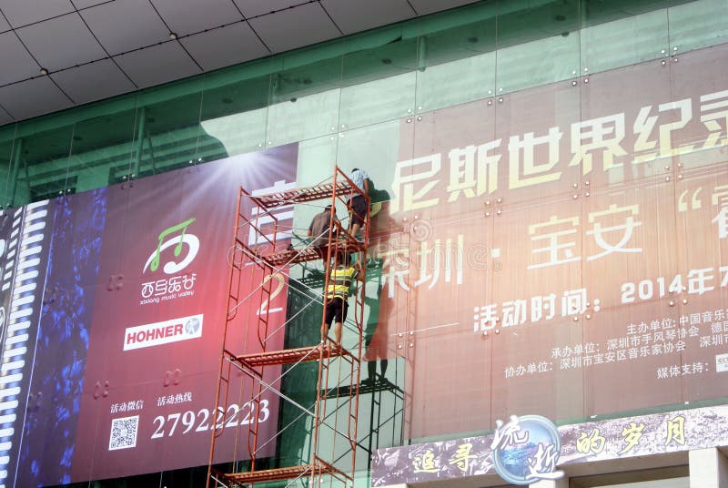 Shenzhen, China: installation of advertising signs. Shenzhen Baoan Xixiang, the workers install billboards at high altitude royalty free stock image