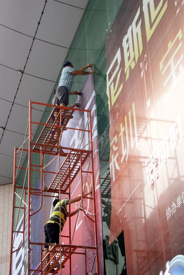 Shenzhen, China: installation of advertising signs. Shenzhen Baoan Xixiang, the workers install billboards at high altitude stock photos