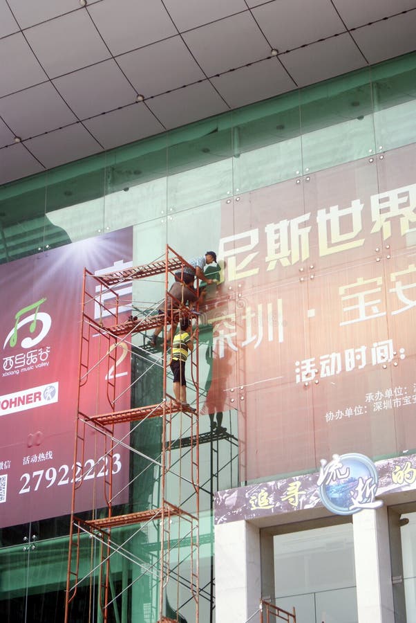Shenzhen, China: installation of advertising signs. Shenzhen Baoan Xixiang, the workers install billboards at high altitude royalty free stock image