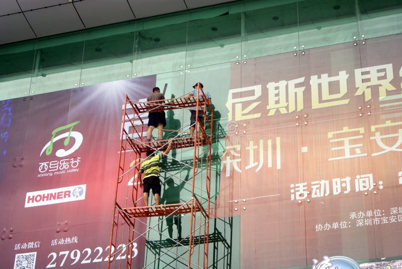 Shenzhen, China: installation of advertising signs. Shenzhen Baoan Xixiang, the workers install billboards at high altitude stock images