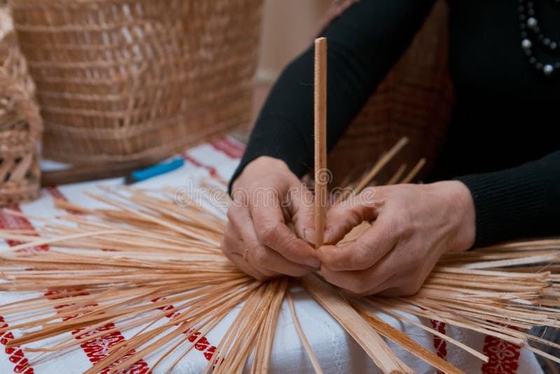 Skilled woman plaits a straw bag at ethnographic master class, traditional craft art at ethnographic master class. Vinnytsia, Ukraine - 19.03.2018: skilled woman stock image