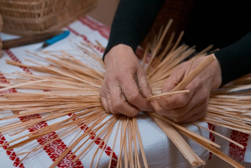 Skilled woman plaits a straw bag at ethnographic master class, traditional craft art, Vinnytsia, Ukraine, 19.03.2018. Vinnytsia, Ukraine - 19.03.2018: skilled stock photography