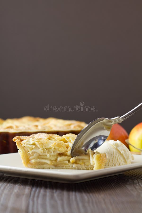 Slice of apple pie and ice cream with spoon, vertical royalty free stock photo
