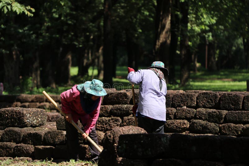 Workers are clearing weeds grass for renovate area of archaeological site at Sri Thep ancient town. Sri Thep, Petchaboon, Thailand, Sep 06, 2018: Workers are stock photos