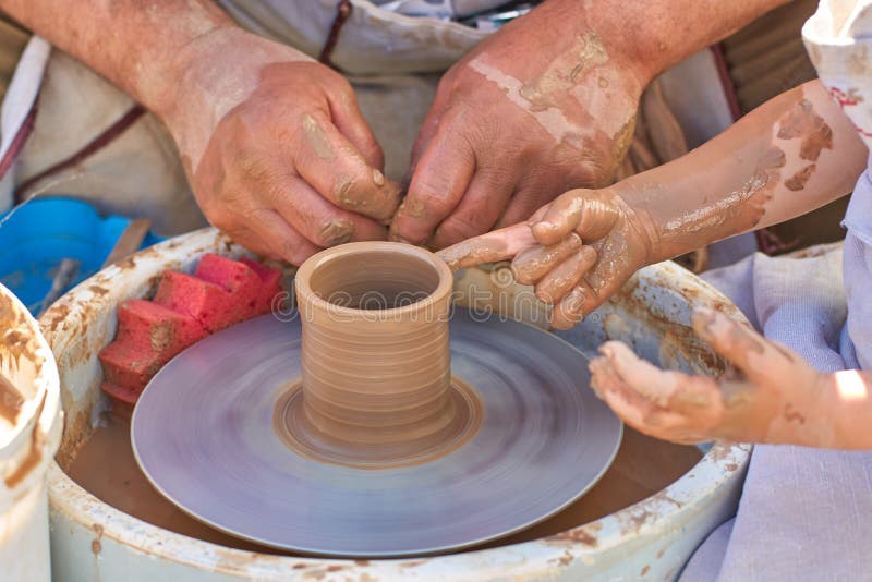 Training pottery, hands of a child and a master on clay, close-up. Training pottery, hands of child and a master on clay, close-up royalty free stock photos