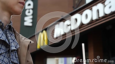 Minsk, Belarus, june 23, 2017: McDonald`s soft drink. Woman drinks a drink in background of McDonald`s restaurant stock footage