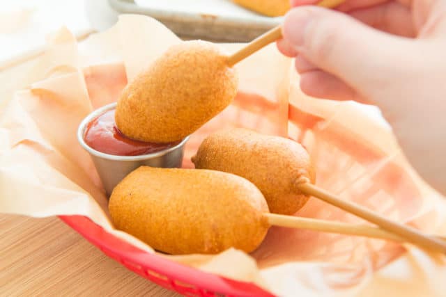 Corndogs - In Basket Dipping Into Ketchup